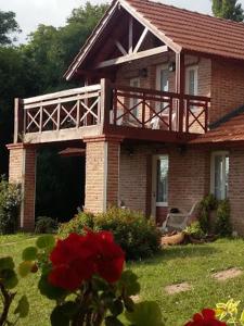 a house with a balcony on top of it at Cabañas Dalga Inn in Merlo