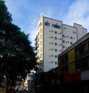 a tall white building on the side of a street at Serema Palace Hotel in Lavras