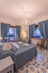 a bedroom with a large bed and blue curtains at B&B Villa Cristina in Anacapri