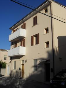 - un bâtiment blanc avec des balcons sur le côté dans l'établissement Elclaca, à Alghero