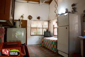 a kitchen with a refrigerator and a bed in a room at Hostal Roldan in Coveñas