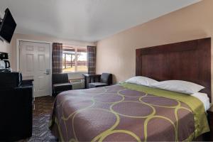 a bedroom with a bed and a dresser at Budget Lodge Eugene - Airport in Eugene