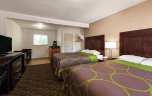 a hotel room with two beds and a flat screen tv at Budget Lodge Eugene - Airport in Eugene