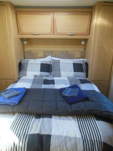 1 dormitorio con 1 cama grande con sábanas azules y blancas en Silverdale Retreat, en Orewa