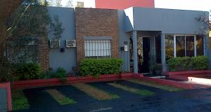 a brick house with a driveway in front of it at La Posada de Los Fresnos in Colón