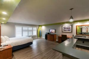 a bedroom with a bed and a desk and a sink at The SeaScape Inn in San Francisco