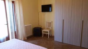 1 dormitorio con 1 cama y TV en la pared en Hotel Dory, en Albinia