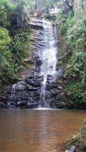 a waterfall on the side of a river at Pousada dos Tucanos in São Thomé das Letras
