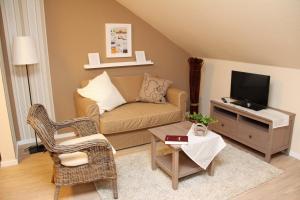 a living room with a couch and a tv at Station L in Langballig