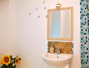 uma casa de banho com um lavatório e um espelho em One Love Central Studio II em Bucareste