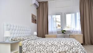 a white bedroom with a bed and a window at One Love Central Studio II in Bucharest