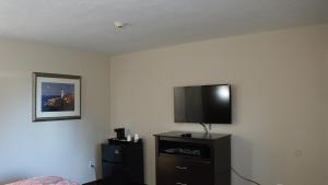 a living room with a television and a bed at Best Stay Inn in Plainville