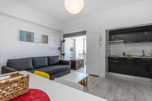 a living room with a couch and a kitchen at Beach Houses in Costa da Caparica