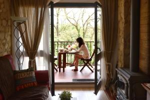 a woman sitting at a table on a porch at Cova Safaja in San Quírico Safaja