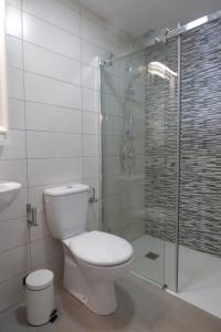 Un baño con inodoro y ducha de cristal. en Casa Berriel 1, en Tías 5 fotos más