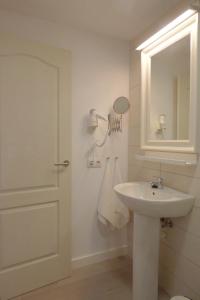 Baño blanco con lavabo y espejo en Casa Berriel 1, en Tías