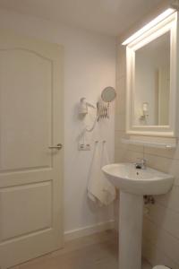 Un baño blanco con lavabo y espejo. en Casa Berriel 1, en Tías