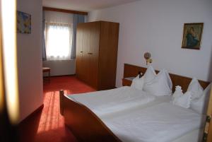 1 dormitorio con 1 cama grande con sábanas blancas en Rosumerhof, en Leutasch