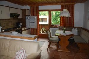 cocina y sala de estar con sofá y mesa en Rosumerhof, en Leutasch