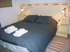1 dormitorio con 1 cama con 2 toallas en Vista II Apartments en San Carlos de Bariloche