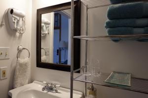 a bathroom with a sink and a mirror and towels at Aspen Inn in Creede