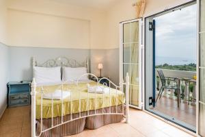 a bedroom with a bed and a balcony at Elaias Gi Residence in Mousata