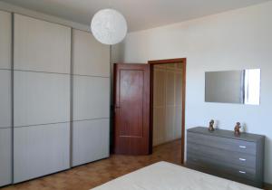 Schlafzimmer mit einem Bett, einer Kommode und einem Spiegel in der Unterkunft Casa Cloe in Isola