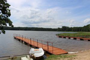 un muelle con un barco en el agua en Domek Letniskowy Brożówka, en Kruklanki