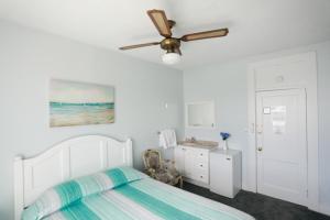 a bedroom with a bed and a ceiling fan at Mayfair Hotel in Belmar