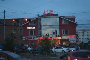 een rood gebouw met een bord dat landhotel leest bij Land Hotel in Ulaanbaatar