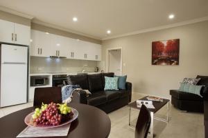 a living room with a couch and a table with a bowl of fruit at Renmark Holiday Apartments in Renmark