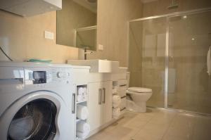 a bathroom with a washing machine and a toilet at Renmark Holiday Apartments in Renmark