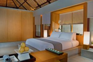 
a hotel room with a bed, desk and a television at The Bale in Nusa Dua
