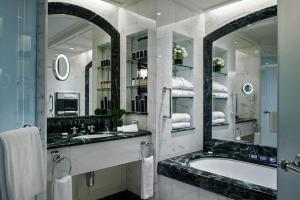 bagno con vasca, lavandino e specchi di The Peninsula Hong Kong a Hong Kong