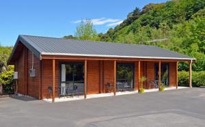 a large white building with a wooden roof at Leith Valley Holiday Park and Motels in Dunedin