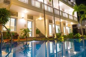 a large swimming pool in a building with a large building at Qli Hotel Muine in Mui Ne