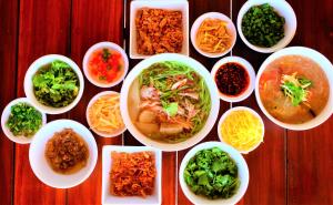 a group of bowls of food on a wooden table at Villa Tha Maphrao in Ban Pa Khlok
