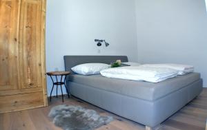a bed with two pillows and a table in a room at Chalet Ur-Gmiatli in Grafendorf bei Hartberg