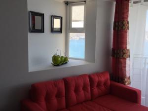 a red couch in a living room with a window at Apartment Joet La Herradura in Coquimbo