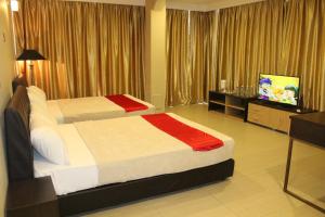 Habitación de hotel con 2 camas y TV de pantalla plana. en T Hotel Jalan Tar en Kuala Lumpur