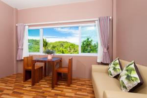 een woonkamer met een bank, een tafel en een raam bij Greenery Resort Koh Tao in Ko Tao