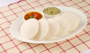 a plate of food with a bowl of dipping sauce at The Shades Holiday inn in Kushālnagar