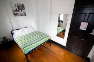 a bed sitting in a room next to a wall at Nomads Brisbane in Brisbane