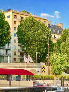 um edifício com um dossel vermelho em frente a um edifício em Appartement Seine et Marais em Paris