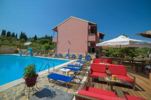 a pool with red and blue lounge chairs and an umbrella at Othonas Apartments in Sidari