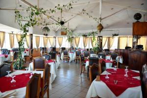 a restaurant with tables and chairs with red tablecloths at Anjary Hotel Antananarivo in Antananarivo