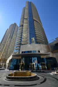 un edificio alto con una fuente frente a él en Icon Casa Living - Trident Grand Residence, en Dubái
