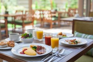 a wooden table with plates of food and glasses of orange juice at Grand Nikko Tokyo Daiba in Tokyo