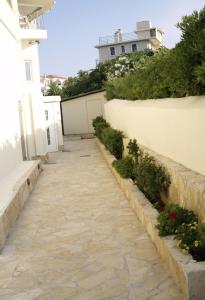 a sidewalk in front of a white building at Nikolaki Rooms in Porto Rafti