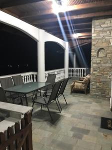 a patio with a table and chairs on a balcony at Villa Paradisos in Likóstomon